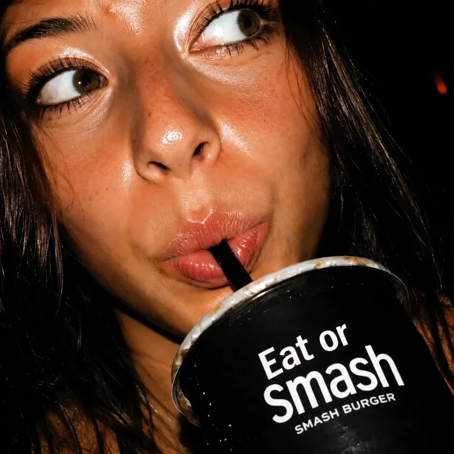 Ragazza che beve con la cannuccia dal bicchiere How I Met Your Smash